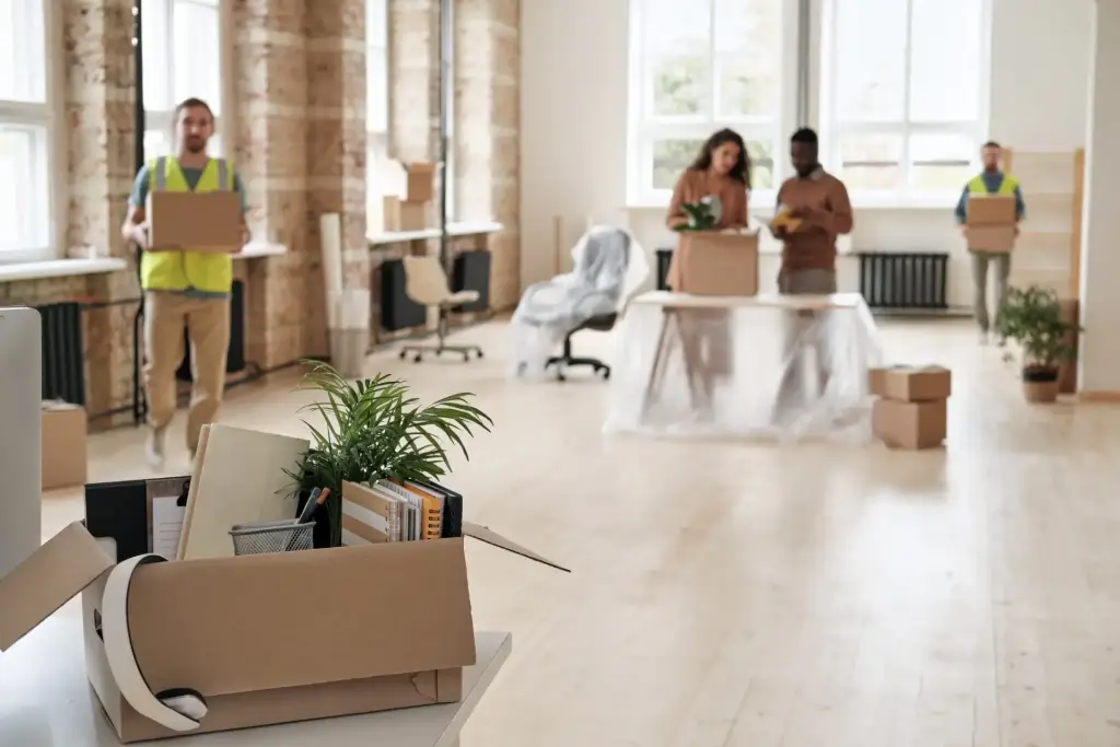Team packt Umzugskartons in einem hellen Büro beim Firmenumzug in Singen